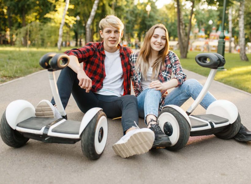 couple-sitting-on-road-with-gyro-board-MSLGQ7C.jpg